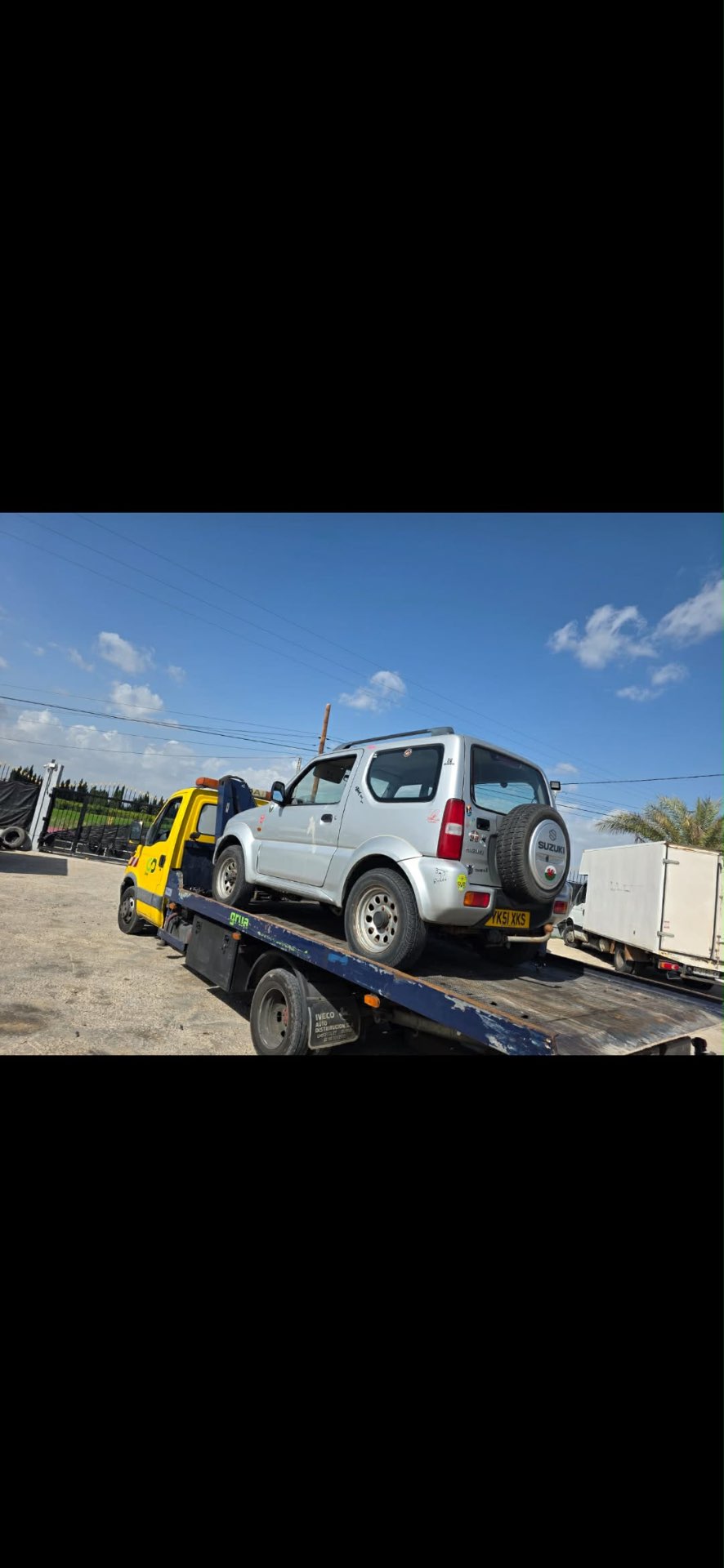 Camión grúa recogiendo un vehículo en una calle de Alicante